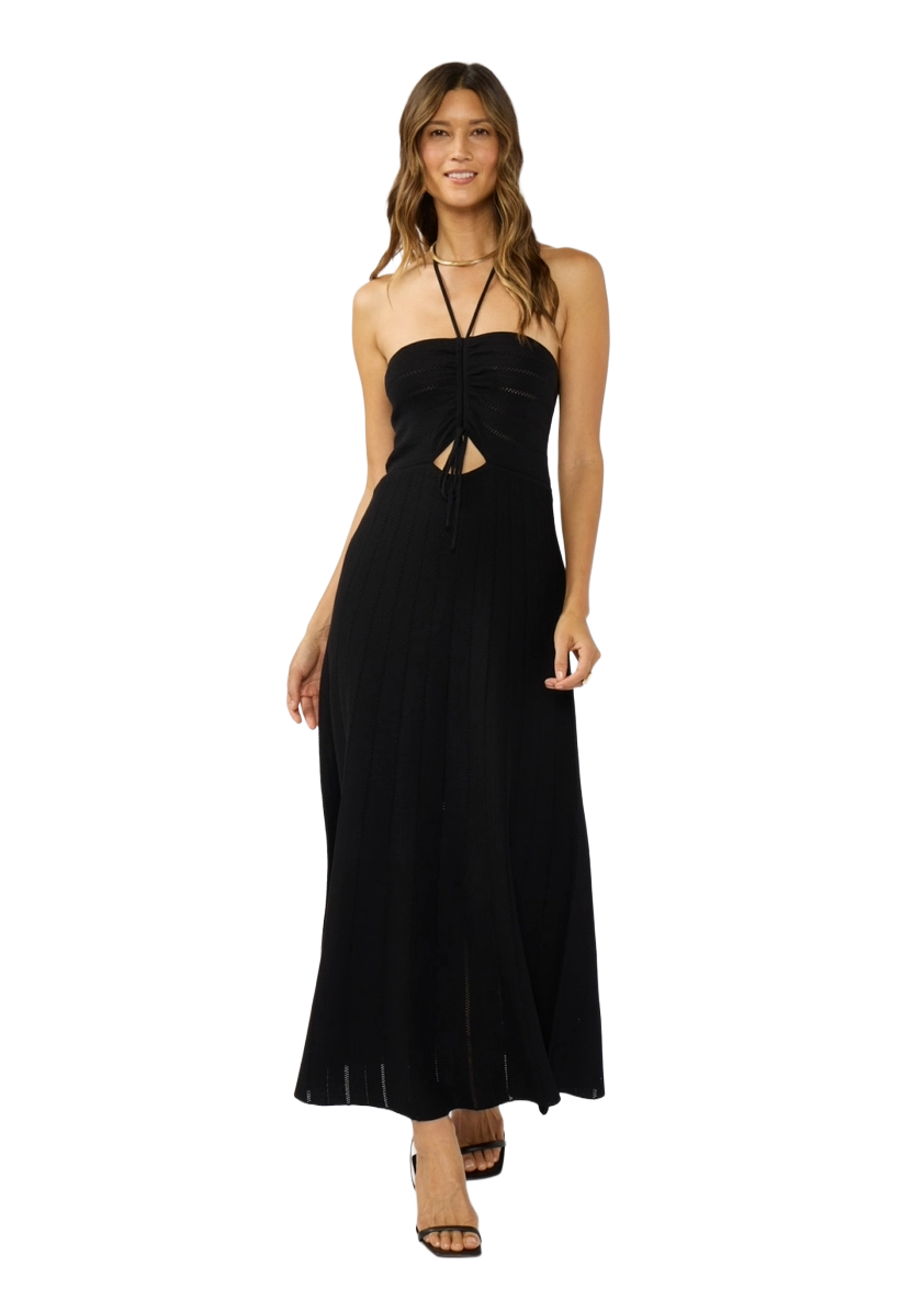 Woman wearing a black pointelle knit halter dress with ruched front and flowing hemline.