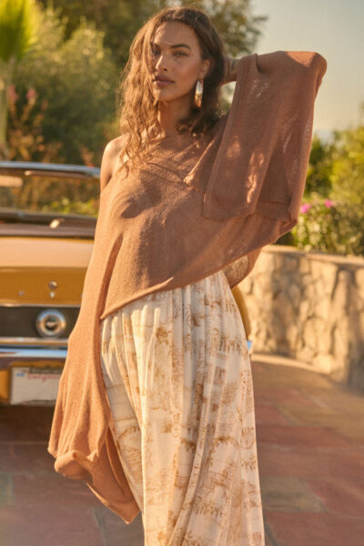 Sheer lightweight knit cropped poncho sweater with flowing sleeves in an earthy tone.